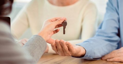 cropped image of happy mature couple getting keys