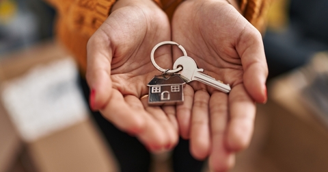woman holding key of new house at new home 