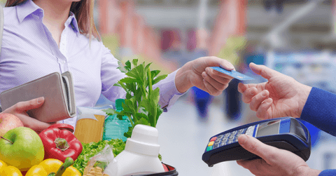 person using credit card on groceries
