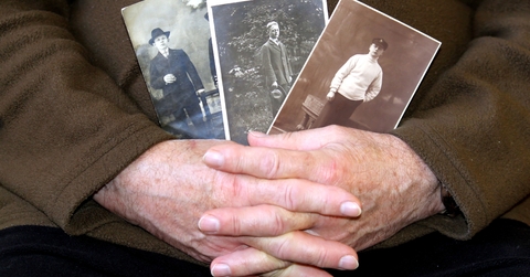 A senior holding an old photos