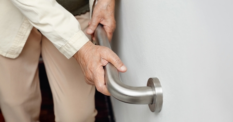 elderly woman holding handrail