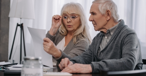 couple sitting at table and looking at bills