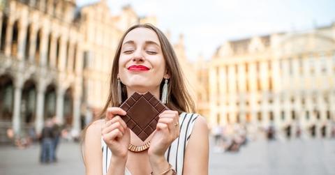 woman with dark chocolate bar standing outdoors