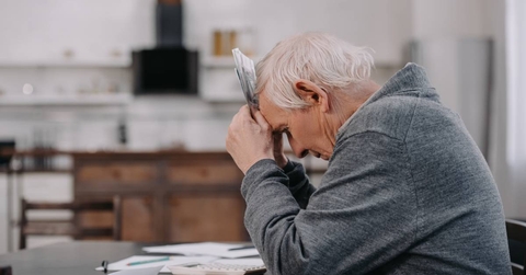 Stressed senior man sitting at table