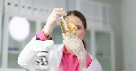 Chemist looking at flask