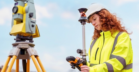 Red head woman in yellow jacket uniform working with mapping and surveying