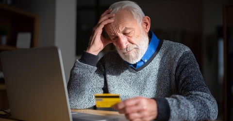 Senior man looking worried while holding a credit card