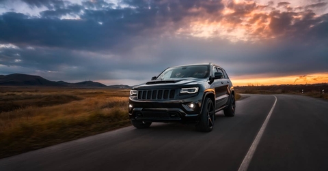 2022 Jeep Grand Cherokee drives on the road at sunset