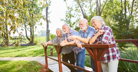 senior group is standing on a small bridge