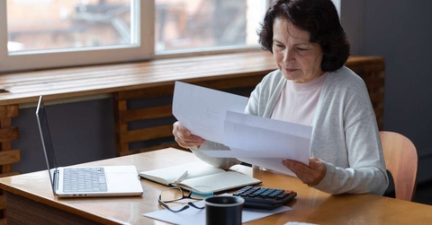 woman sit with laptop and paper document