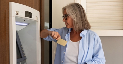 middle-aged woman wants to withdraw money from an ATM