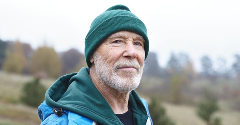 older man outdoors wearing a green beanie