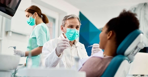 smiling dentist with face mask