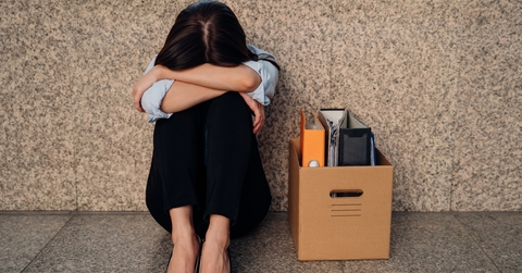 woman hiding her face after being laid off from job