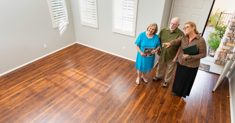 real estate agent showing to senior couple a new home