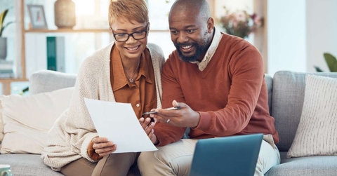 couple on sofa check bank account