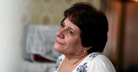 Pensive older woman looking out through window