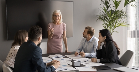 manager makes speech in front of employees at the office