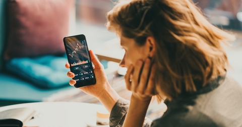 woman using mobile phone investing 