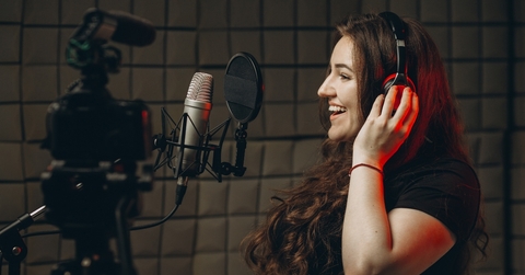 Woman recording voice in studio