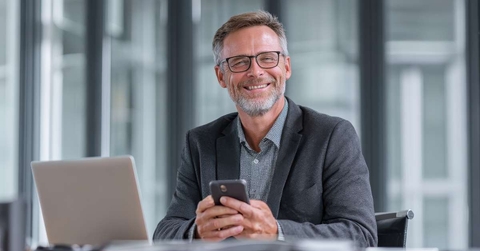smiling businessman holding smartphone