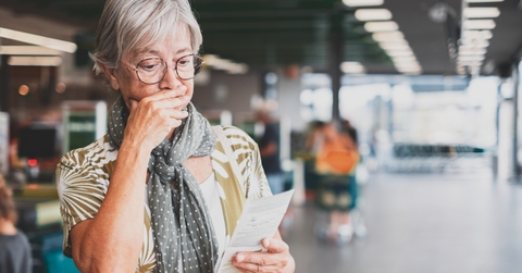 senior woman checks her grocery receipt