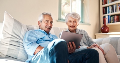 happy senior couple watching on tablet together