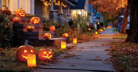 Halloween pumpkins on residential sidewalk at dusk