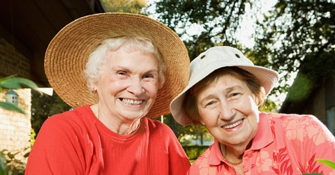 Two senior women smiling in the garden