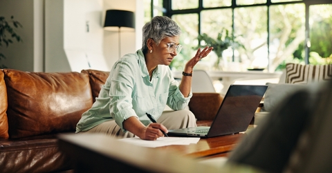 Woman looking confused with laptop and notes