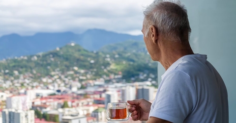retired man viewing city on balcony