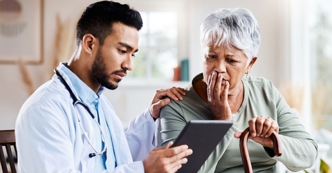 older woman sitting with doctor looking concerned