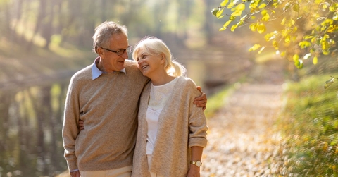 retired couple walking in autumn park