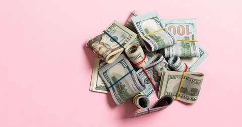 US Dollar bills bundles on pink background