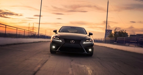 black lexus is driving in city at sunset