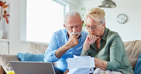 Worried older couple looking at bills