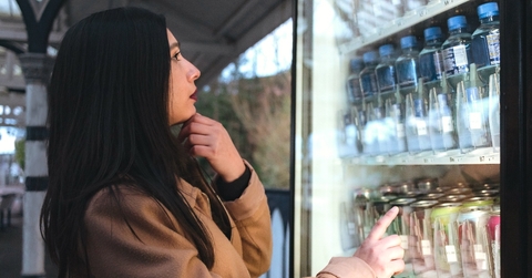 Woman shopping and looking at drinks in refrigerator 