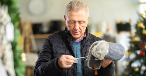 Older man looking at hat price tag
