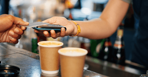 person scanning credit card at coffee shop