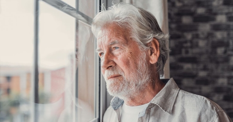 contemplative older man looking out window