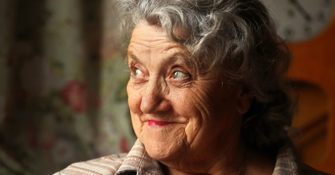 Older woman looking up smiling and thinking