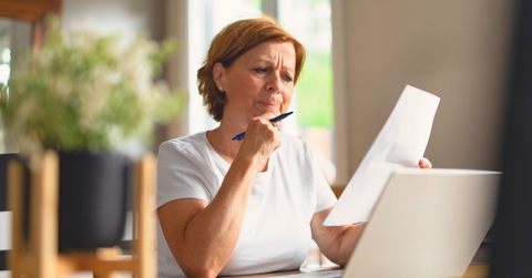 Woman looking at paperwork suspcious