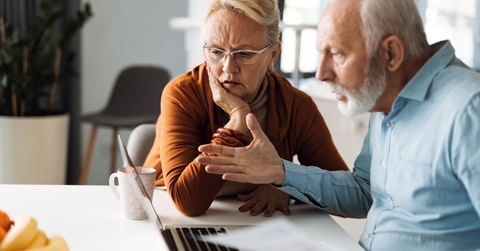 frustrated senior couple on laptop