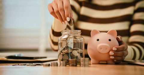 A woman holds a piggy bank