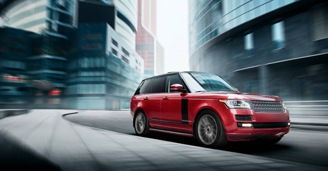 Red car fast drive on a road in a city at daytime 