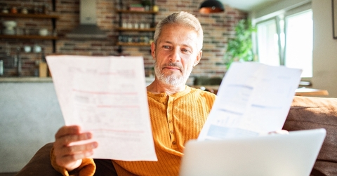 Man in his 50's looking at paperwork at home