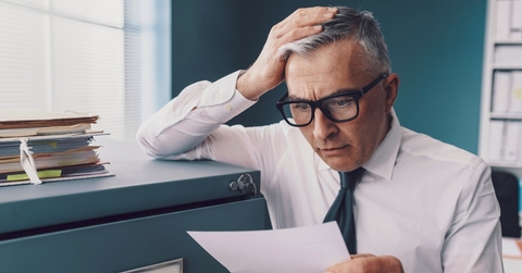 Finance man looking at document surprised and worried