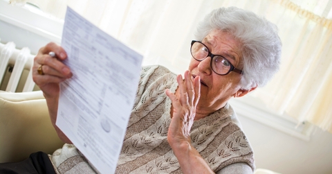 Retired senior woman looking at document worried