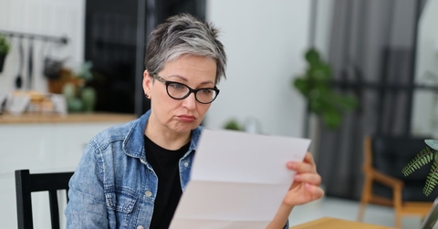 Confused Gen X retired woman reviewing a letter