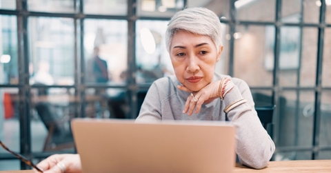 Thoughtful mature business woman on laptop